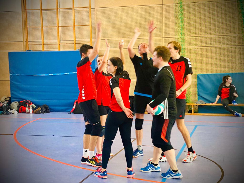Volleyballteam klatscht gemeinsam ab.